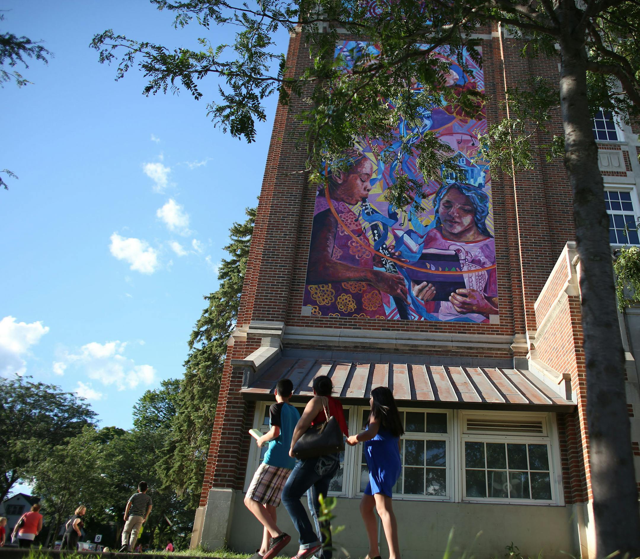 Parents and students gaze up at the new mural during the school's open house. ] (KYNDELL HARKNESS/STAR TRIBUNE) kyndell.harkness@startribune.com Unveiling of the Folwell Performing Arts Magnet school's mural in Minneapolis , Min., Thursday August 20, 2015. "Connections Mural" More than 700 people in the neighborhood helped paint this mural over the past six months.