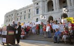 Gov. Tim Walz, flanked by his wife, Gwen, right, and Lt. Gov. Peggy Flanagan, speaks Wednesday, Aug. 7, 2019, during a rally against gun violence at t