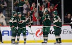 Wild center Frederick Gaudreau is congratulated by Ryan Hartman (38), Marcus Foligno (17) and Sam Steel (13) during the second period Saturday