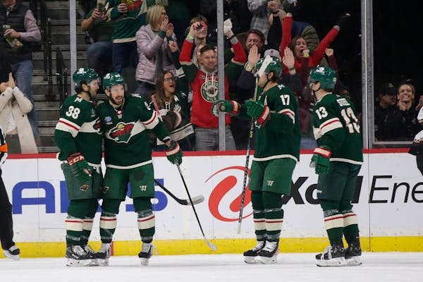 Wild center Frederick Gaudreau is congratulated by Ryan Hartman (38), Marcus Foligno (17) and Sam Steel (13) during the second period Saturday