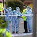 Forensics officers gesture near the scene of an attack in Hainault, north east London, Tuesday April 30, 2024.