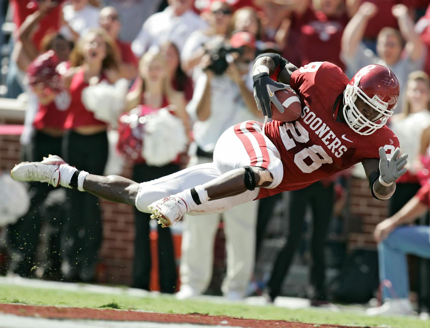 Oklahoma's Adrian Peterson dives into the end zone to score a touchdown on a 53-yard run in the fourth quarter against Iowa State in a football game Saturday, Oct. 14, 2006, in Norman, Okla. Peterson broke his collarbone on the play. (AP Photo/The Oklahoman, Nate Billings) ORG XMIT: OKOKL101