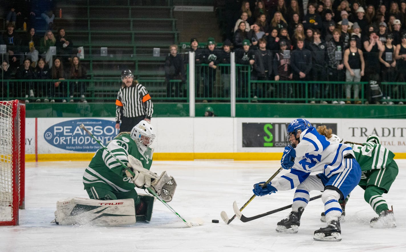 Holy Family goaltender Sedona Blair (30) makes a save on Minnetonka forward Ava Lindsay (9) during the first period of the Class 2A Section 2 girl's hockey championship Friday, Feb. 17, 2023 at Braemar Arena in Edina, Minn. ]