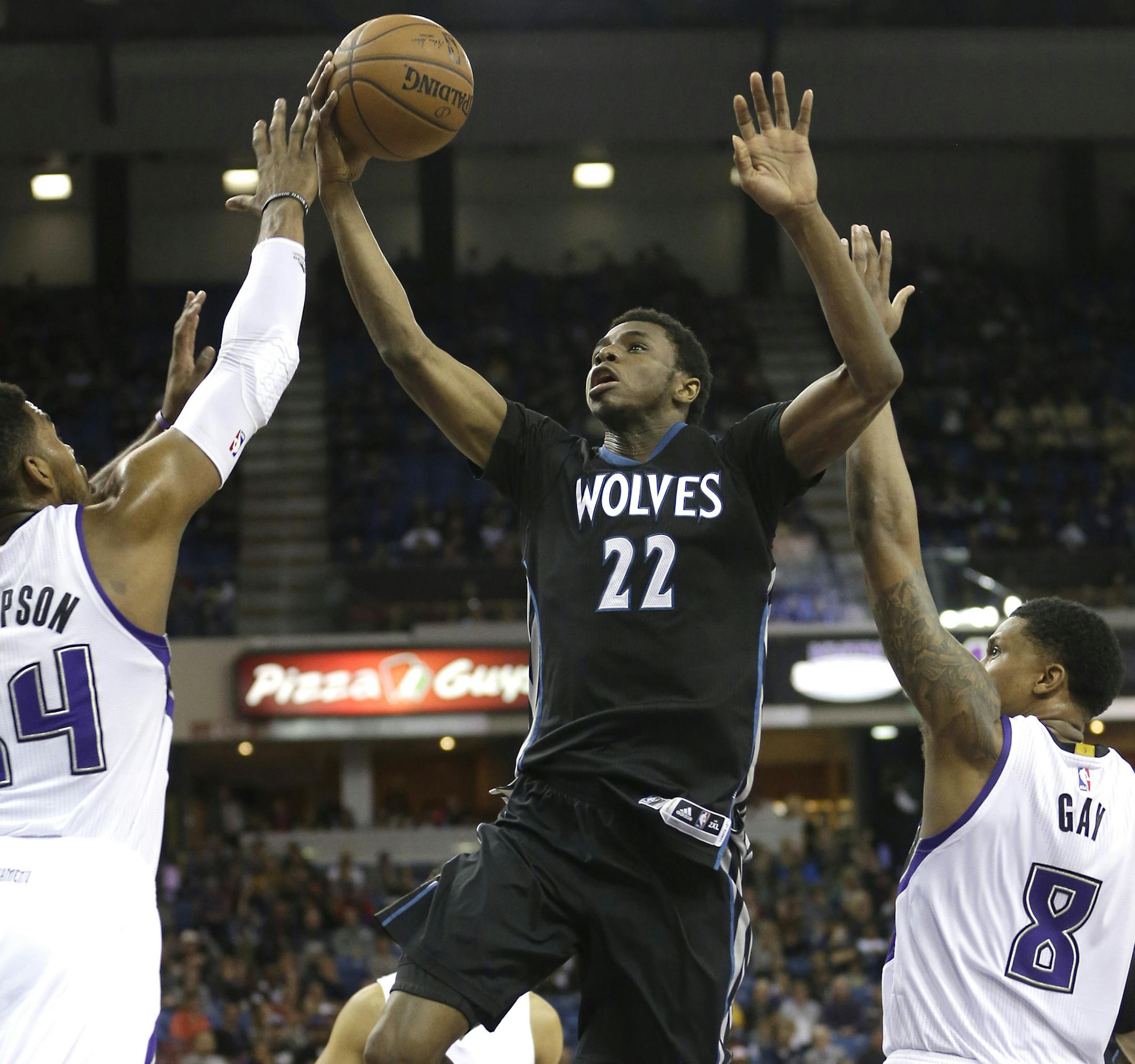 Minnesota Timberwolves forward Andrew Wiggins, center, drives to the basket between Sacramento Kings' Jason Thompson, left, and Rudy Gay during the first quarter of an NBA basketball game in Sacramento, Calif., Calif., Tuesday, April 7, 2015.(AP Photo/Rich Pedroncelli) ORG XMIT: SCA102