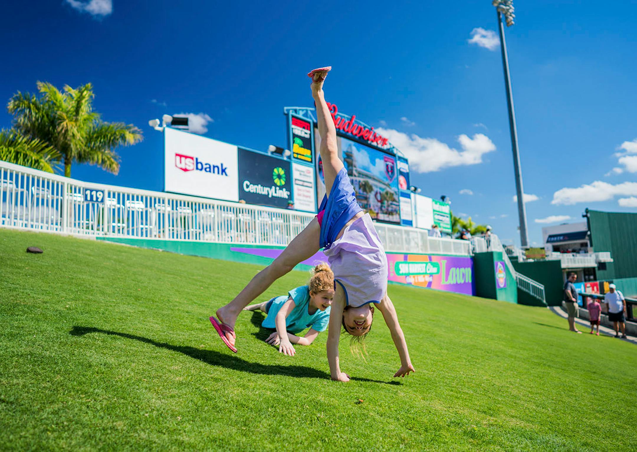 Eight-year-old Becca Chestovich of St. Paul kartwheeled down the lawn at Hammond Stadium while nine-year-old Katherine Campbell tumbled behind her.