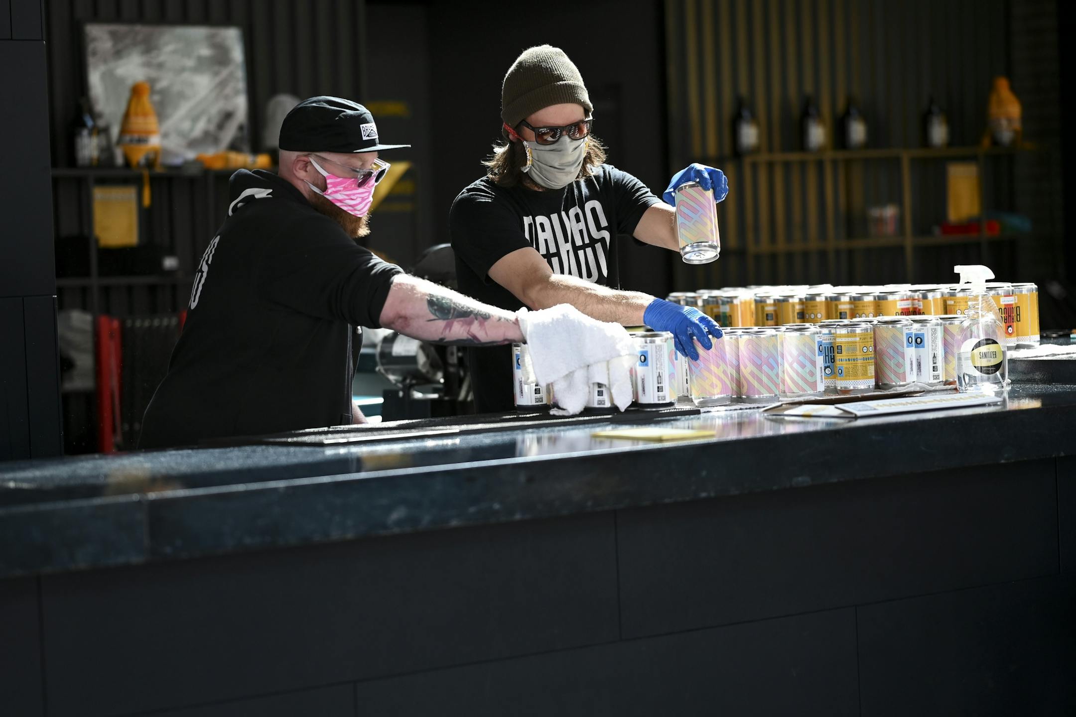 Bauhaus Brew Labs co-owner Mark Schwandt, left, and brewer Dan Larsen dried off crowlers while fulfilling pick up orders Friday afternoon.