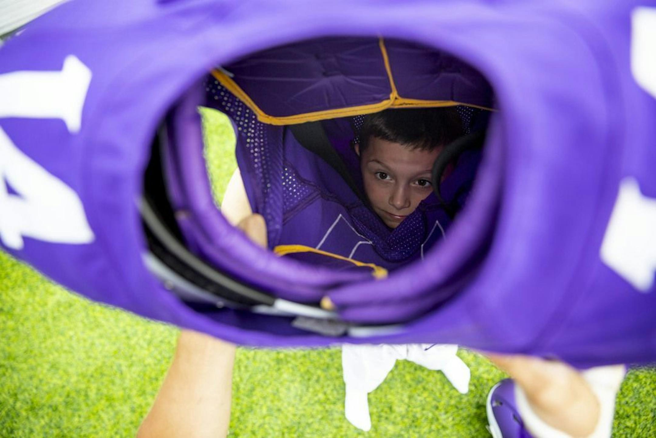 Kaden Hoffman looked up through the top of the Stefon Diggs jersey as he struggled to wiggle his way into the shoulder pads as part of one of the "Kids Combine" stations in the Kid's Zone at Vikings training camp. ALEX KORMANN • alex.kormann@startribune.com The Minnesota Vikings opened up their first full day of training camp on Friday July 26, 2019 at TCO Performance Center in Eagan, MN. Doors opened to fans at 11AM to watch their favorite players practice and get excited for the 2019 NFL seaso