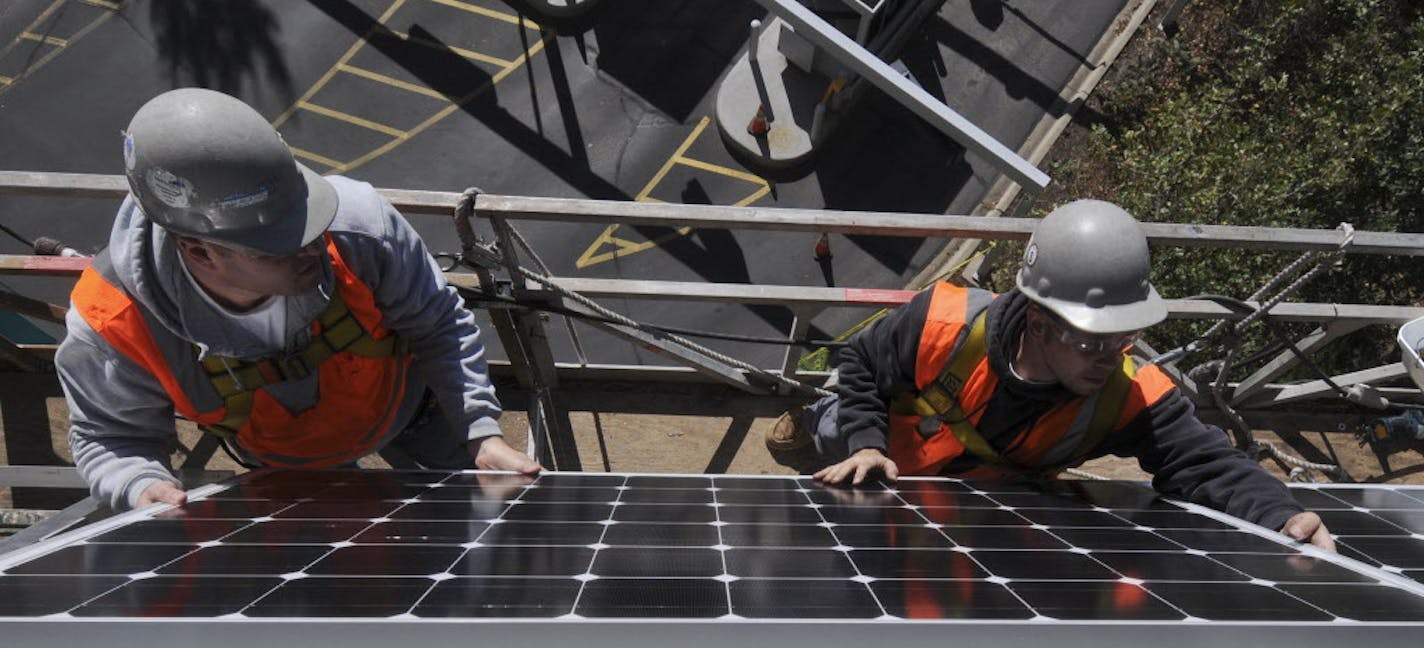 Workers installed solar panels on the side of the Saint Paul RiverCentre Parking Ramp on Monday afternoon October 17/2011. Saint Paul Mayor Chris Coleman joined Congresswoman Betty McCollum, St Paul City Council member Dave Thune and Xcel Energy Regional Vice President Laura McCarten in a celebration event to officially unveil an 82 kilowatt (kW) solar photovoltaic installation project on the Saint Paul RiverCentre parking ramp] Richard Sennott/Star Tribune. Richard.Sennott@startribune.com St Pa