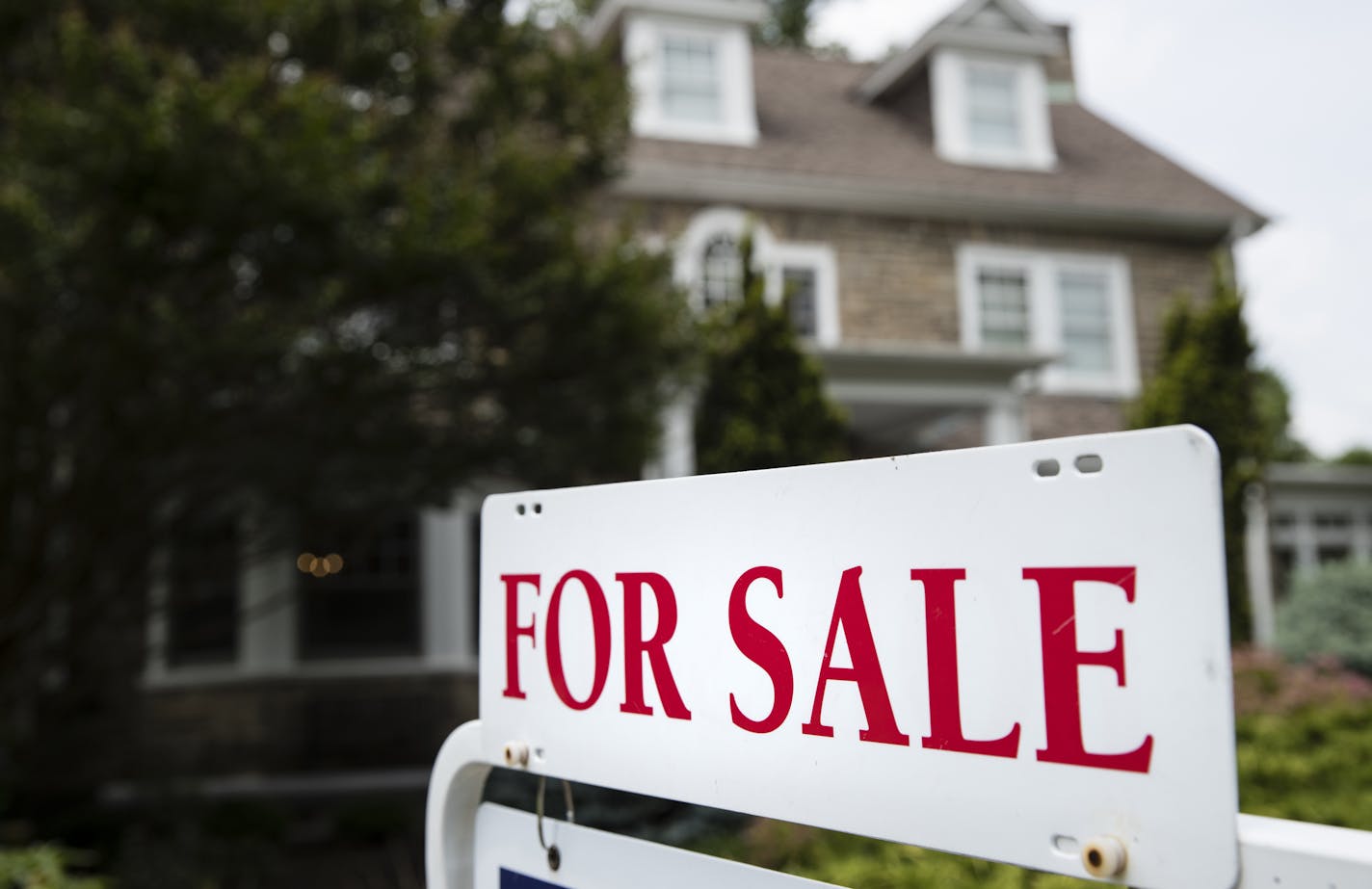 In this Friday, June 8, 2018, photo, a "For Sale" sign stands in front of a house, in Jenkintown, Pa. Home sales in many areas of the country have dipped, and prices gains have slowed. Yet a rising number of middle-class Americans have been priced out of their home markets. (AP Photo/Matt Rourke)