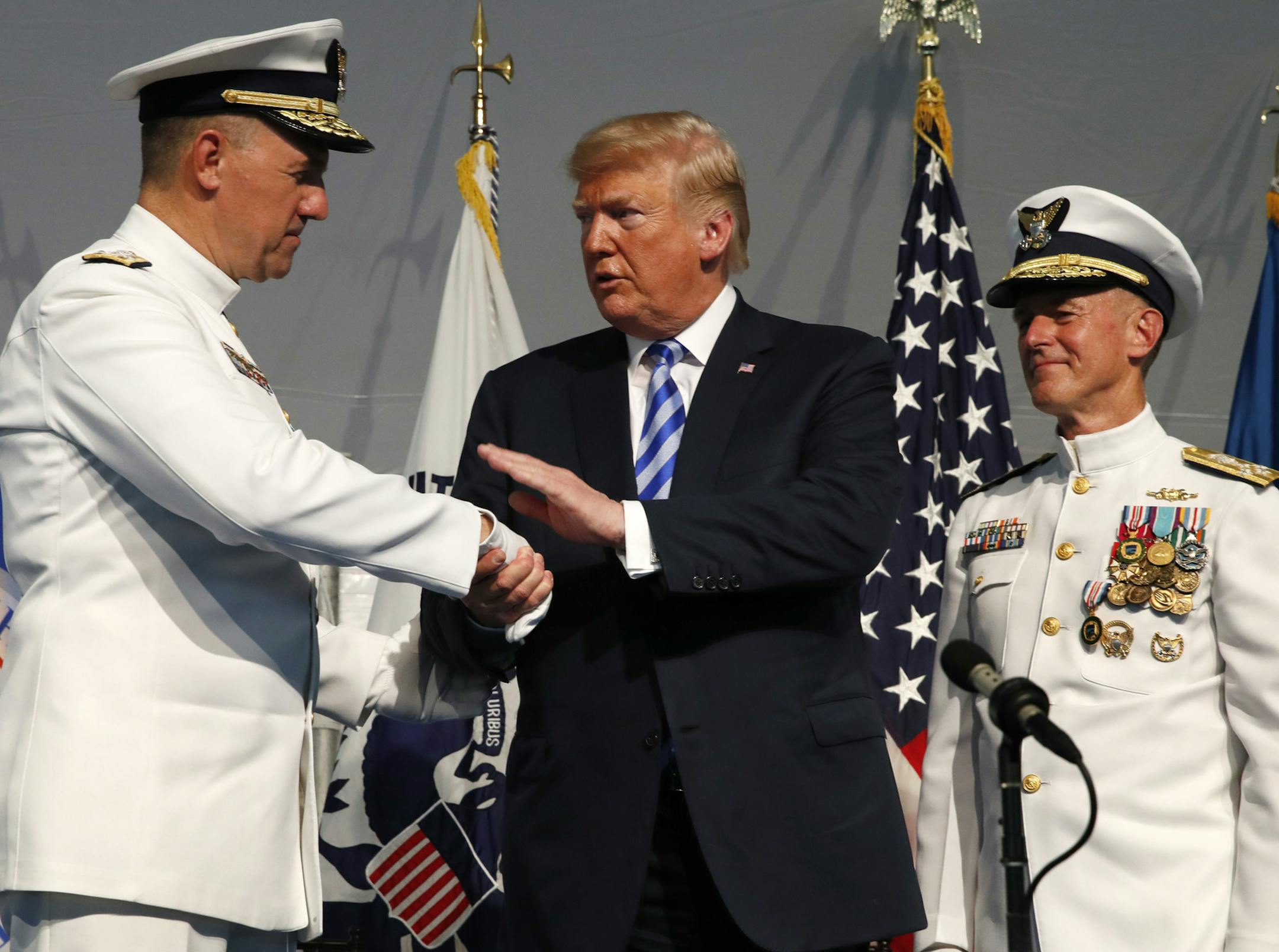 President Donald Trump, center, shakes hands with Coast Guard Adm. Karl Schultz, left, during a Change of Command ceremony at the U.S. Coast Guard Headquarters, Friday, June 1, 2018, in Washington. Adm. Paul Zukunft, right, is being relieved by Schultz as the Commandant of the U.S. Coast Guard. (AP Photo/Jacquelyn Martin)