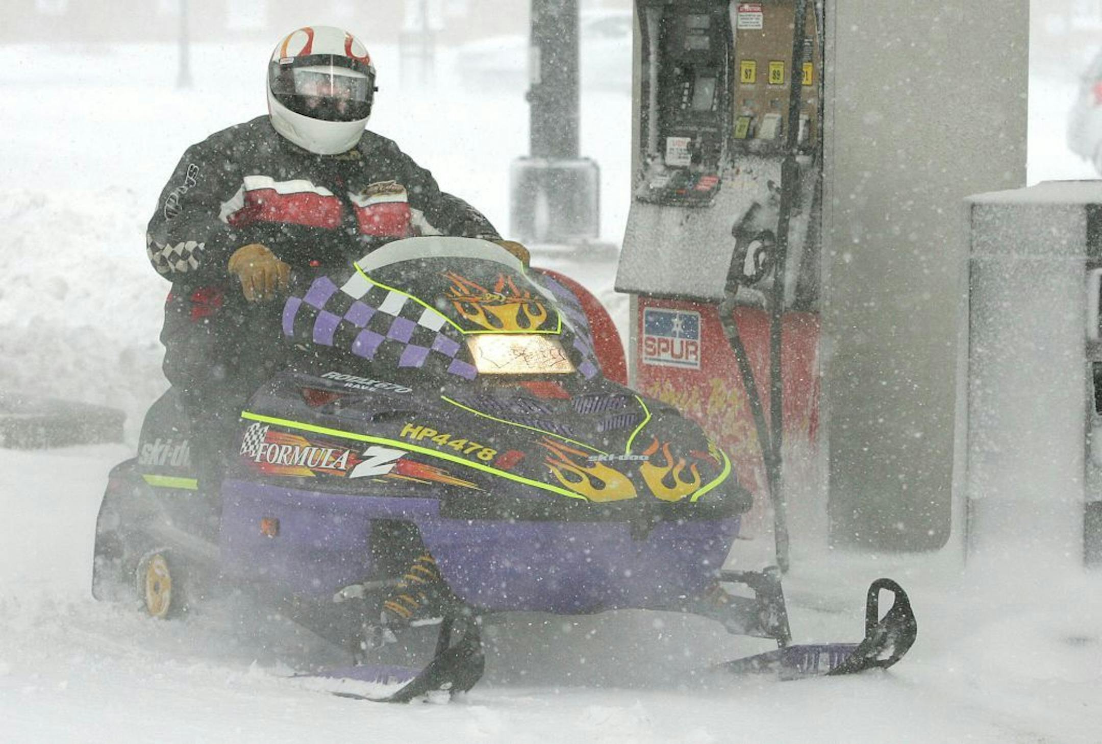 Charlie Vujcevic, of Duluth, Minn., leaves the Spirit Valley Little Store in West Duluth after filling his snowmobile with gas on Wednesday, Feb. 29, ,2012. The National Weather Service issued a winter storm warning for much of Minnesota through Wednesday evening. The heaviest snow is expected in the central region.