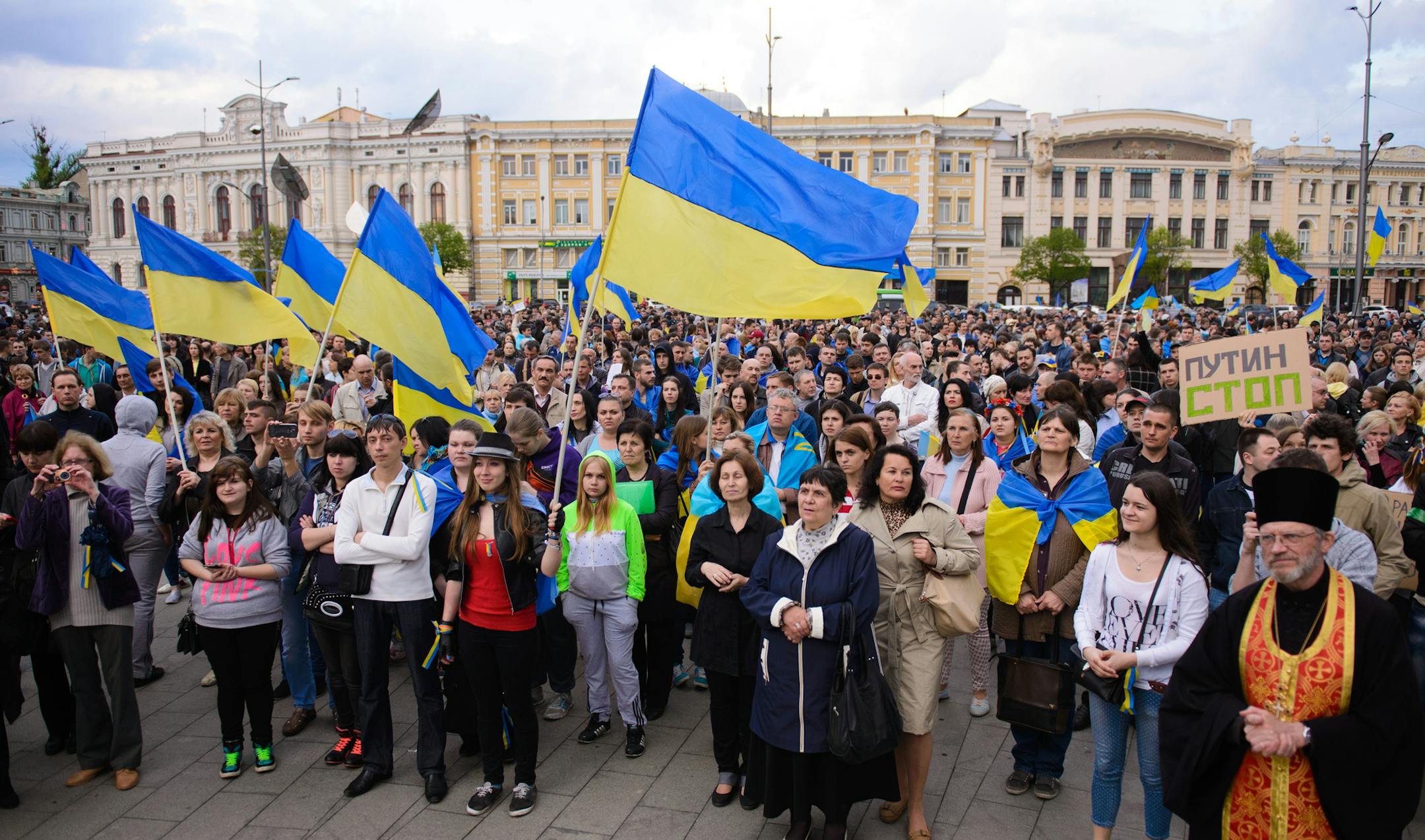 Ukrainians pray during a rally for a united Ukraine in Kharkiv, Ukraine, Wednesday, April 23, 2014. Poster at right reads, "Putin stop". Ukraine's highly publicized goal to recapture police stations and government buildings seized by pro-Russia forces in the east produced little action on the ground Wednesday but ignited foreboding words from Moscow. (AP Photo/Olga Ivashchenko)