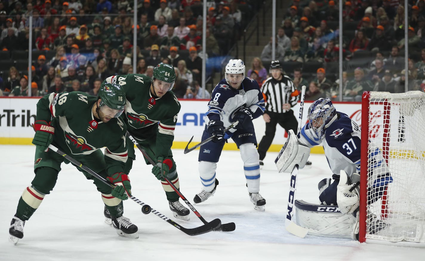 Wild left winger Jason Zucker (16) and right winger Mikael Granlund both tried to redirect a pass from the corner past Jets goalie Connor Hellebuyck in the first period.