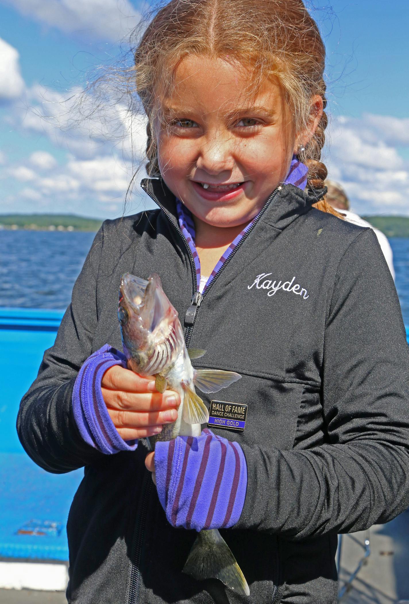 Kayden Collins, 7, brandishes a walleye she caught while fishing with her family last week on a Mille Lacs Lake launch.