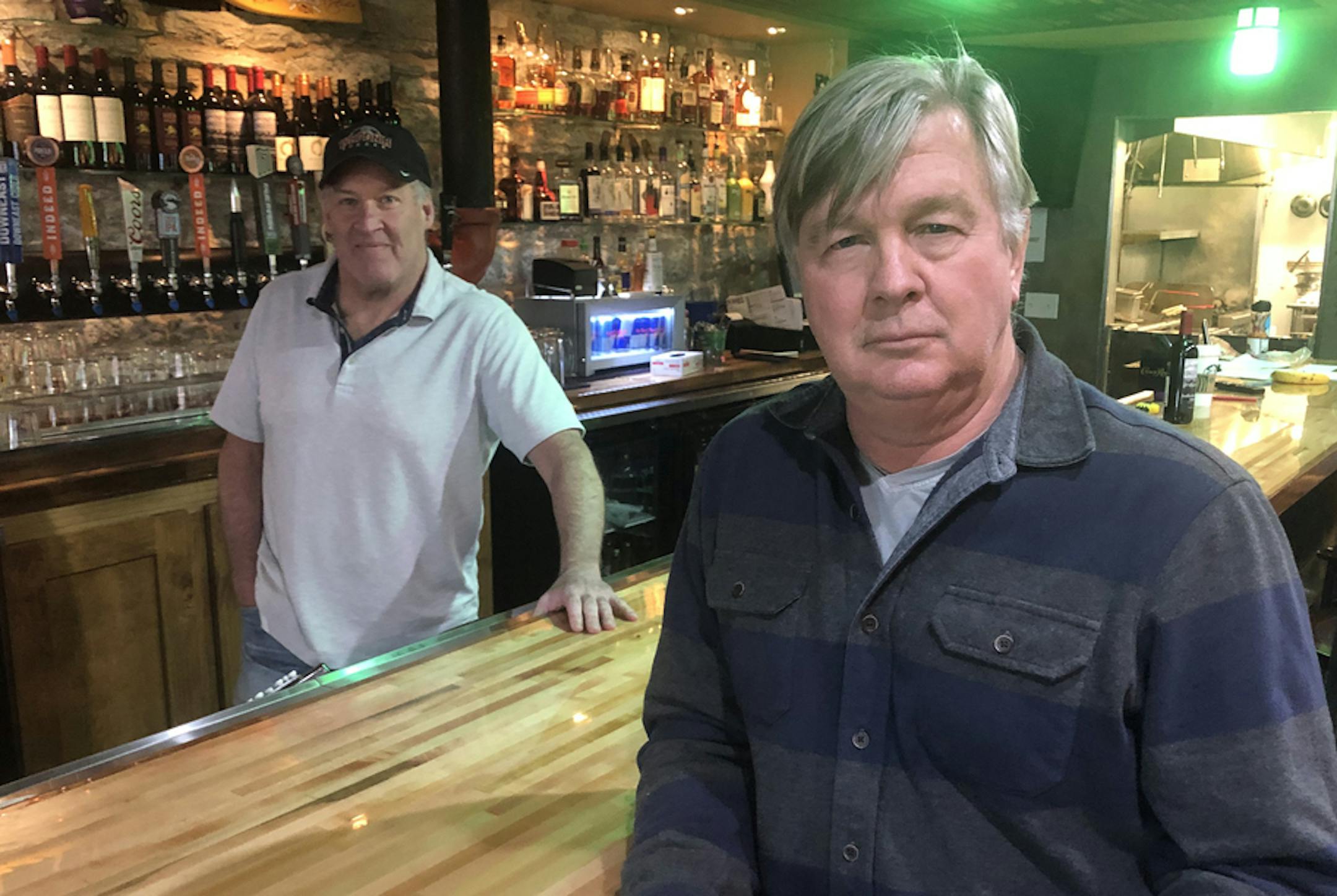 Mike Mulrooney (left, behind bar), owner of Pog Mahones pub near U.S. Bank Stadium, and landlord Mike Roess, owner of iMetro Property, which has about 75 commercial tenants at three small shopping centers in Minneapolis, Burnsville and Woodbury. Photo: Neal.St.Anthony@startribune.com
