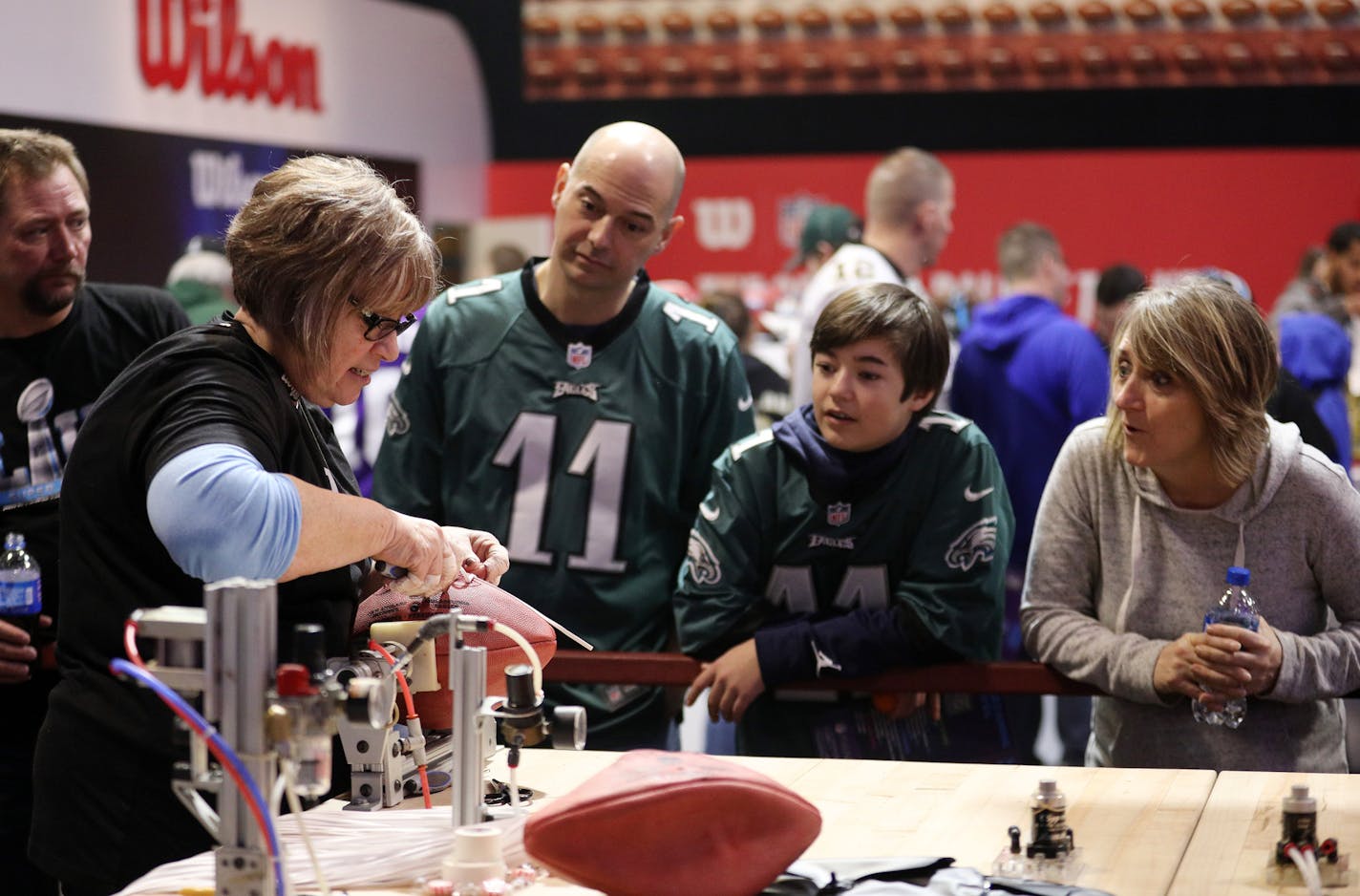 Eagles fans watched as Pamela Boutwell with Wilson laced a football as they watched it being made. ] ANTHONY SOUFFLE &#xef; anthony.souffle@startribune.com Football fans took part in the NFL's Super Bowl Experience, a ticketed event that allowed them to meet NFL players up close, pose with the Vince Lombardi Trophy and participate in flag clinics, Saturday, Jan. 27, 2018 at the Minneapolis Convention Center in Minneapolis.