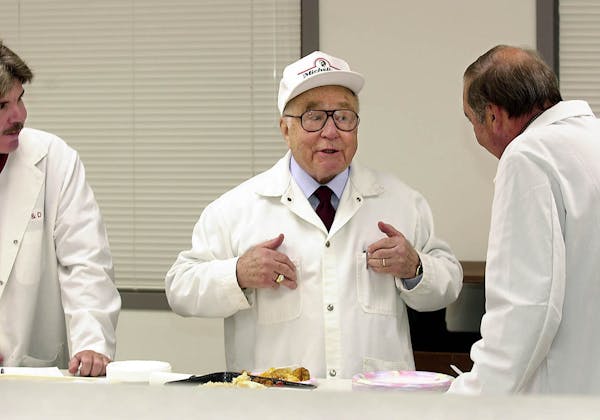 This Aug. 4, 2011, file photo, shows businessman and entrepreneur Jeno Paulucci, center, as he jokes during product testing at his Michelina's food re
