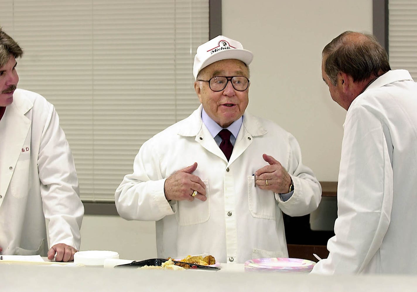 This Aug. 4, 2011, file photo, shows businessman and entrepreneur Jeno Paulucci, center, as he jokes during product testing at his Michelina's food research and development kitchen in Duluth, Minn., Paulucci, a Minnesota business icon whose restaurant ventures included a company that popularized the finger food known as pizza rolls, died, Thursday, Nov. 24, 2011. He was 93.