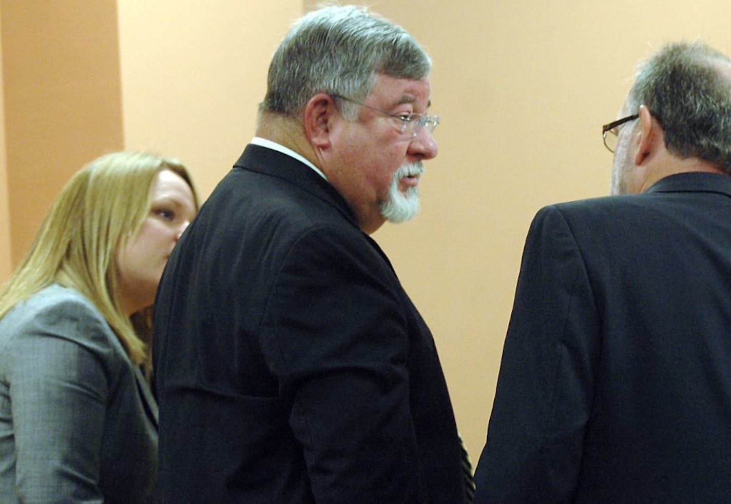 FILE - In this May 20, 2011 file photo, suspended State District Judge Michael Murphy, center, speaks with his defense attorneys Margaret Strickland, left, and Michael Stout during a hearing in the Third Judicial District Court in Las Cruces, N.M. A change of plea hearing is scheduled for Murphy, the retired Las Cruces judge accused of funneling bribes to former New Mexico Gov. Bill Richardson for judicial appointments.