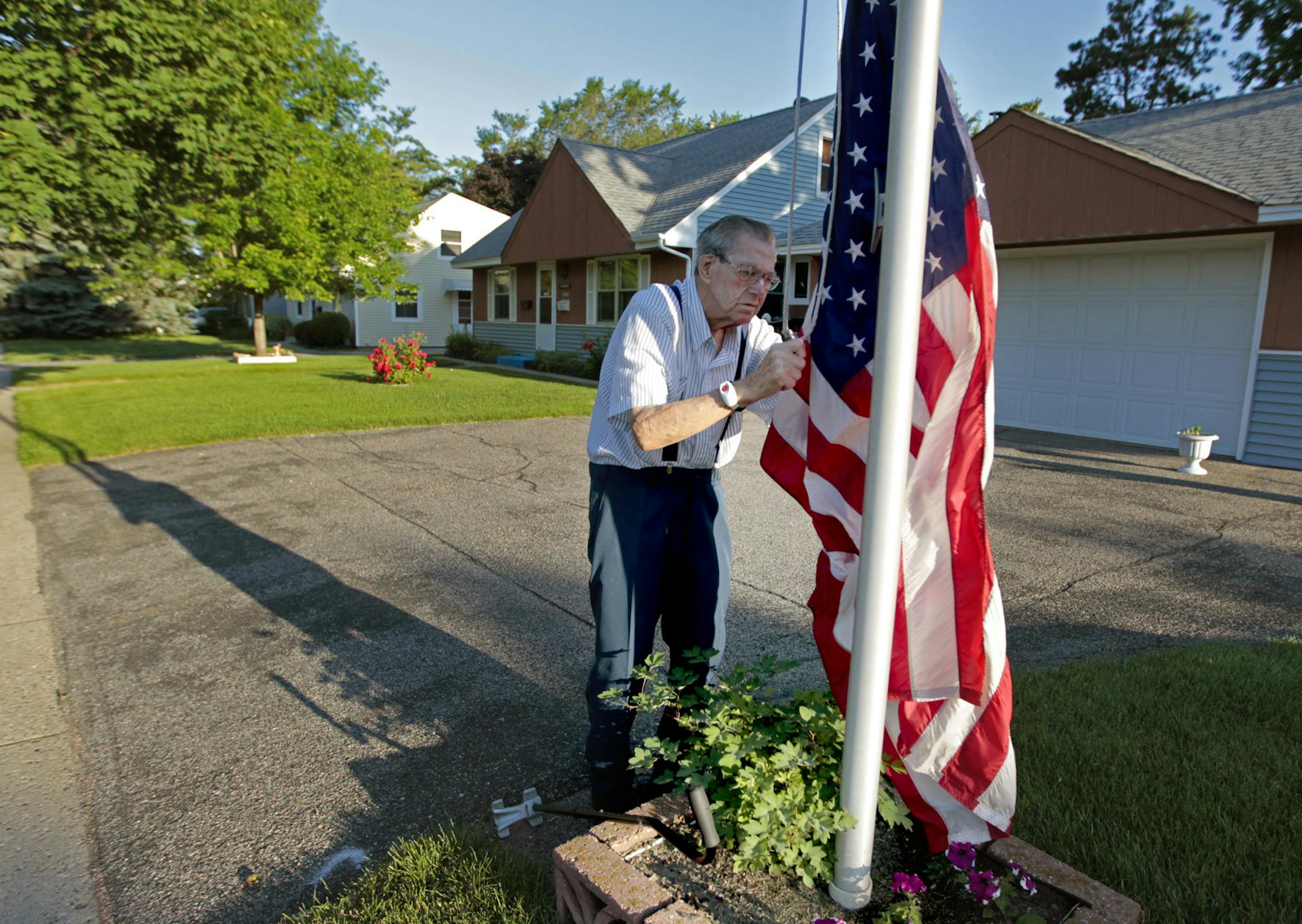 Warren Bushway, 93, hung a flag early Tuesday morning, June 24, 2014 in St. Louis Park, MN. ] (ELIZABETH FLORES/STAR TRIBUNE) ELIZABETH FLORES • eflores@startribune.com