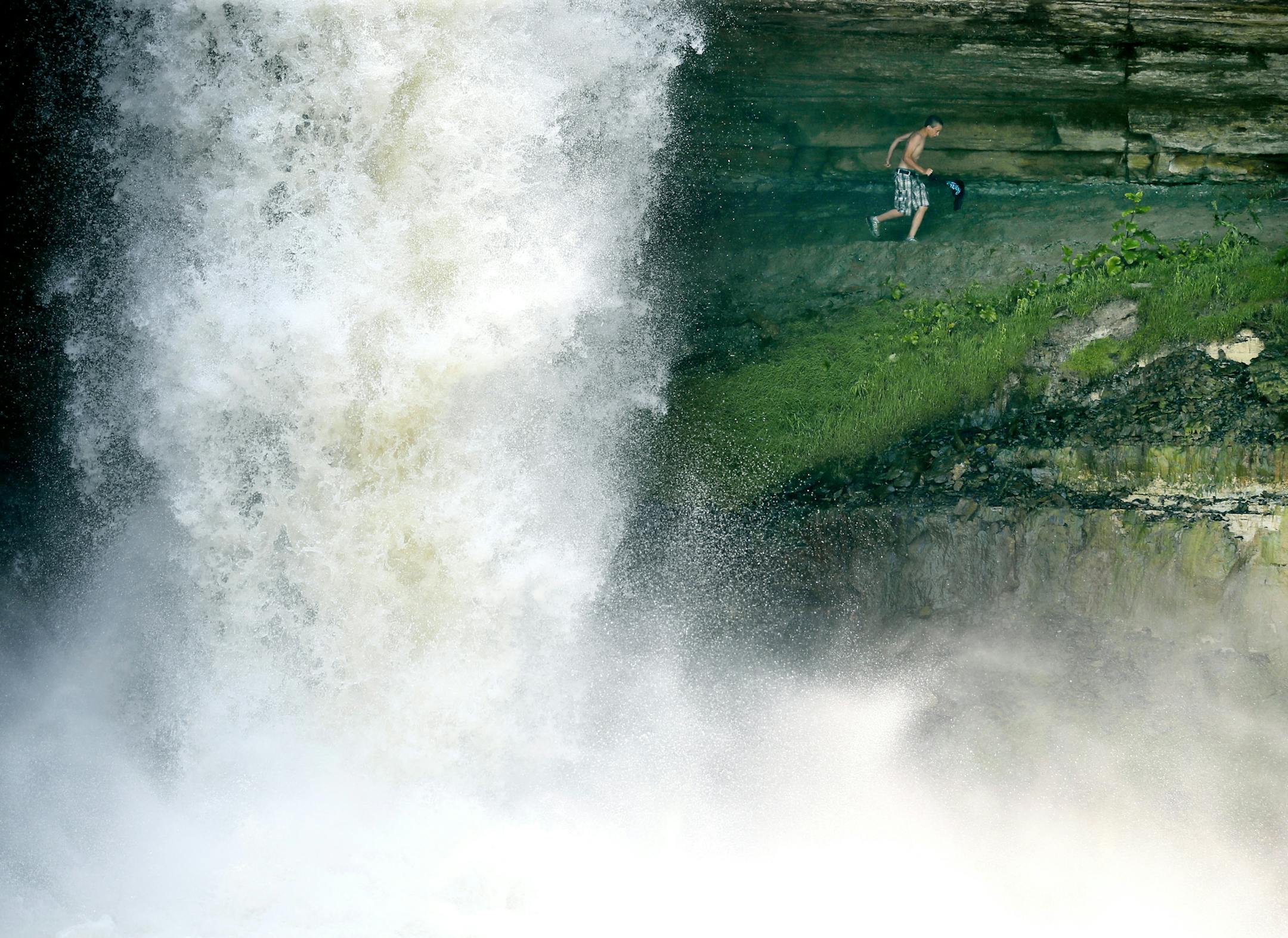 A young man ran from behind the waterfalls at Minnehaha park on Monday afternoon. High water along Minnehaha Creek is prompting safety warnings to canoeists and kayakers as the long July 4th weekend approaches.