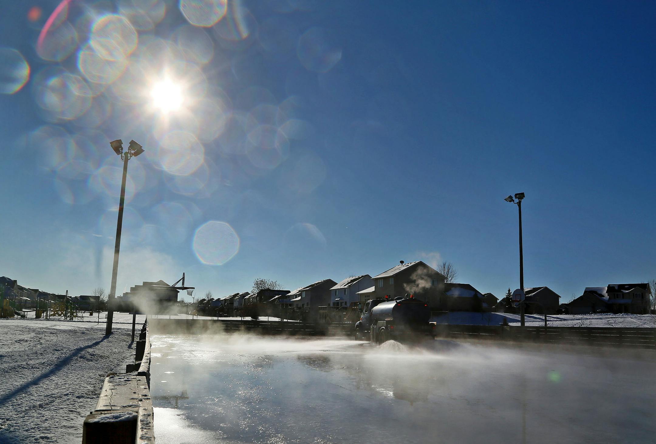 Dean Bisek, a Shakopee Parks Maintenance employee, operates a water tanker truck filled with 2,000 gallons of water while flooding the outdoor hockey rink at Green Meadows Park Tuesday, Dec. 30, 2014, in Shakopee, MN. "Mother Nature needs to cooperate," Bisek said of recent warm weather that has delayed the rink's opening.](DAVID JOLES/ STARTRIBUNE)djoles@startribune.com Unseasonably warm temps in late November and into December have complicated the normal outdoor ice skating rink preparations.
