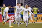 Minnesota United' Emanuel Reynoso, right, celebrates his goal against the Seattle Sounders with teammates Michael Boxall, left, and Jan Gregus during 