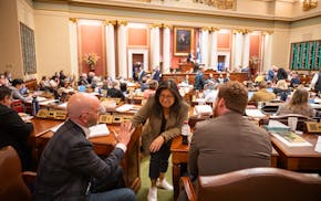 Rep. Kaohly Vang Her (DFL-St. Paul), center, talks to Rep. Brad Tabke (DFL-Shakopee), left, and Rep. Zack Stephenson (DFL-Coon Rapids), right, durin