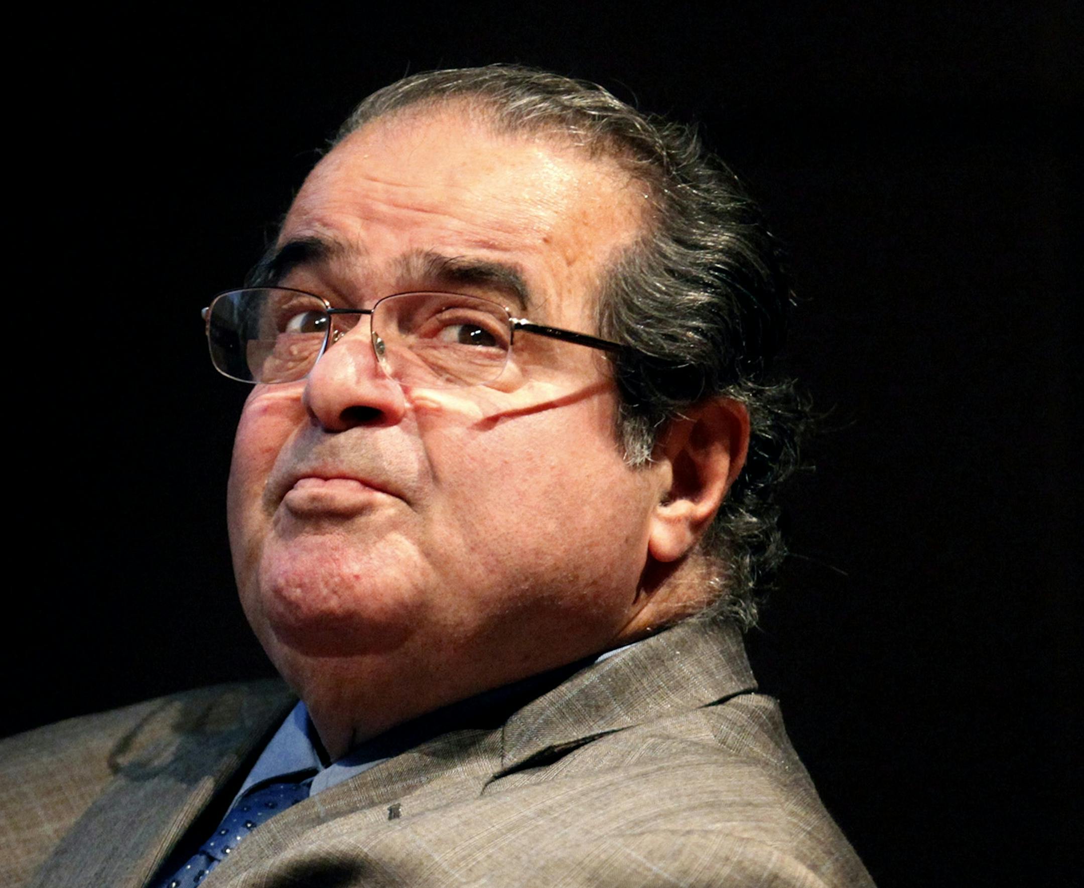 FILE - In this Oct. 18, 2011, file photo, Supreme Court Justice Antonin Scalia looks into the balcony before a speech in Chicago. Scalia died Saturday in Texas. He was 79.