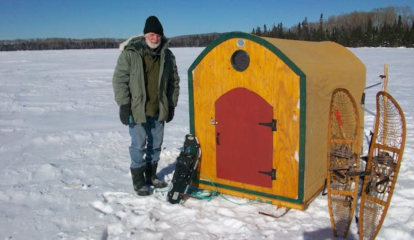 R. Struck, of Grand Marais, stands outside the portable fishing shelter he built this winter.
