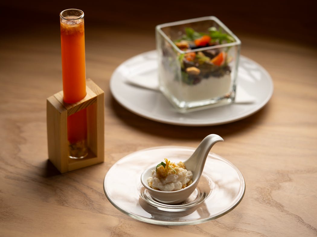 Selections from Crasqui’s six-course tasting menu (from left): Mandarin gazpacho, Casabitos and Orilla y Emociones — mixed greens, toasted peanuts, passion fruit, guayanes foam, and onions.