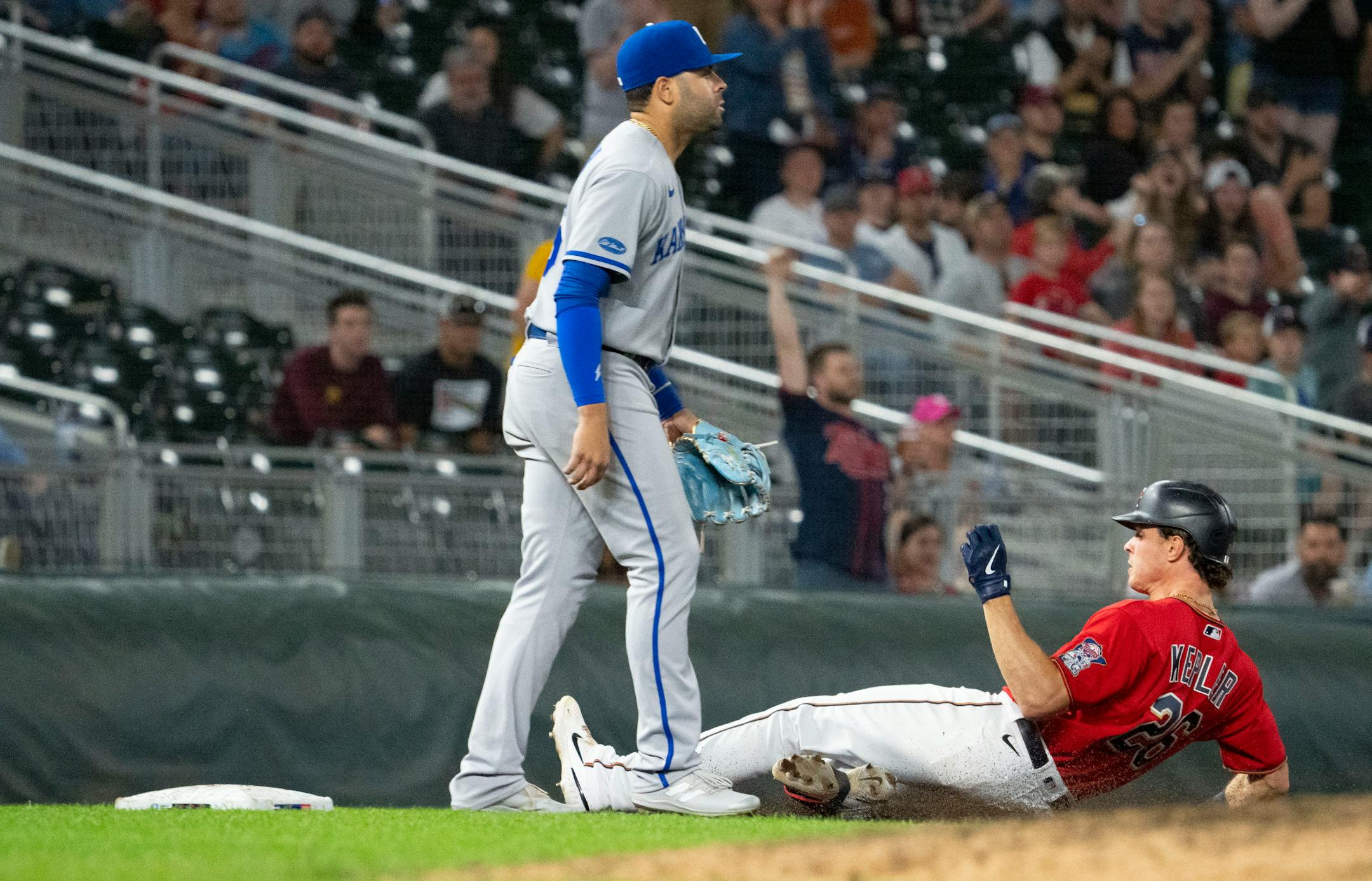 Minnesota Twins right fielder Max Kepler (26) slides into third while Kansas City Royals third baseman Emmanuel Rivera (26) looks into the outfield in the eighth inning.