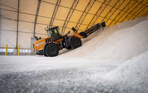 Crews moved salt in a storage shelter to make room for an upcoming delivery at a MnDOT station in Maple Grove on Tuesday. A mild, nearly-snowless wint