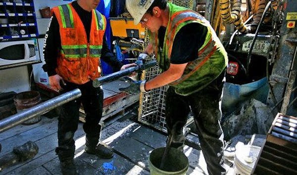 Drillers for Twin Metals, at a site near the Kiwishiwi River, pull a core sample from the drill pipe.