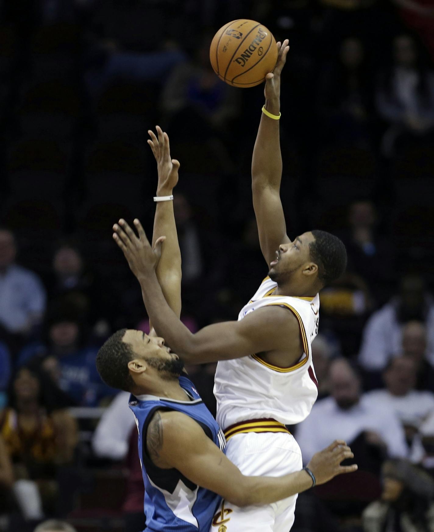 Cleveland Cavaliers' Tristan Thompson, right, shoots over Minnesota Timberwolves' Derrick Williams (7) during the first quarter of an NBA basketball game Monday, Feb. 11, 2013, in Cleveland.