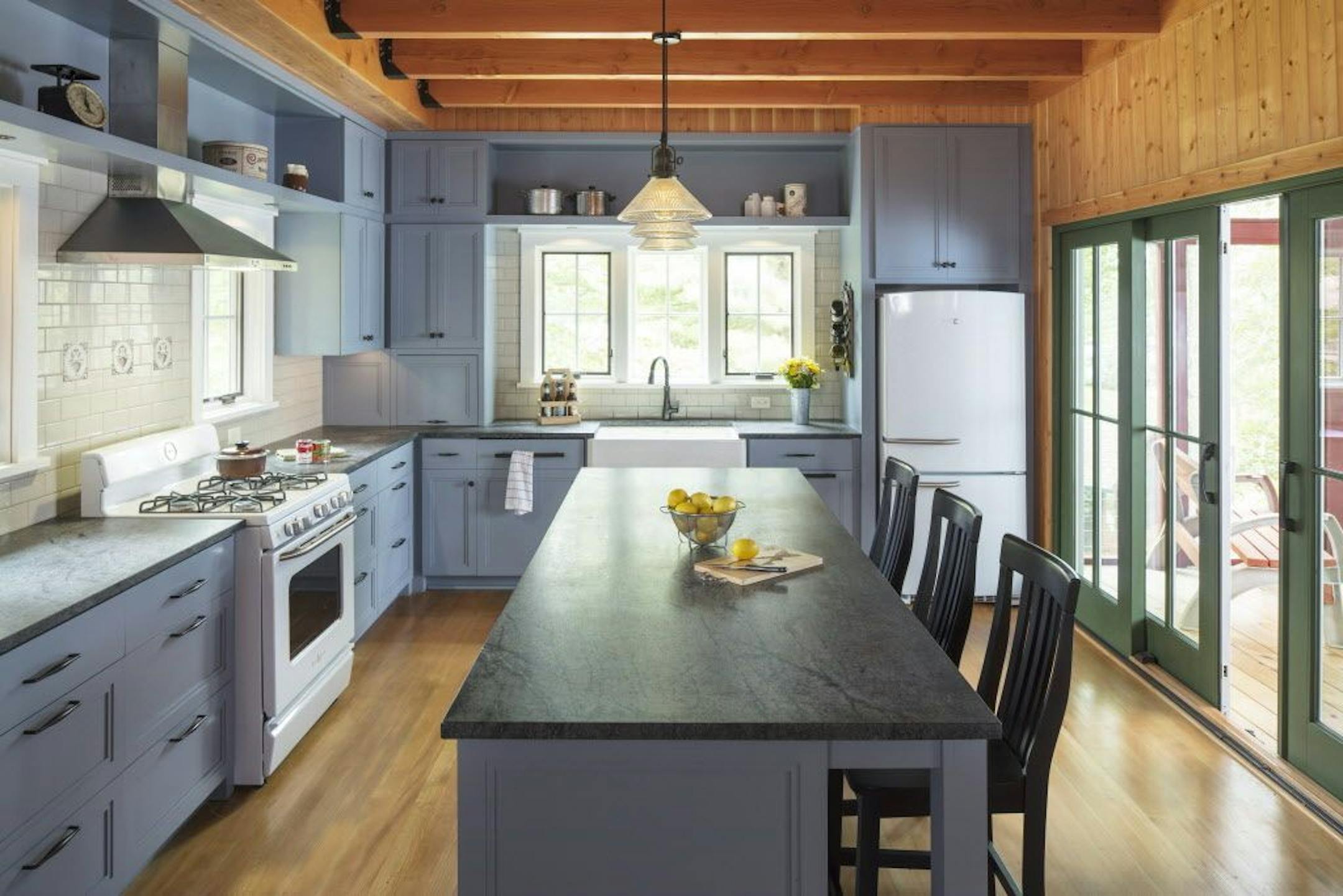 Scandinavian modern kitchen with open and closed blue cabinets, soapstone counters and white appliances, by Mark Larson, Rehkamp Larson Architects.