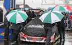 The crew for Trevor Bayne (6) pushes his car to the inspection station as rain falls at Richmond International Raceway in Richmond, Va., Saturday, Apr