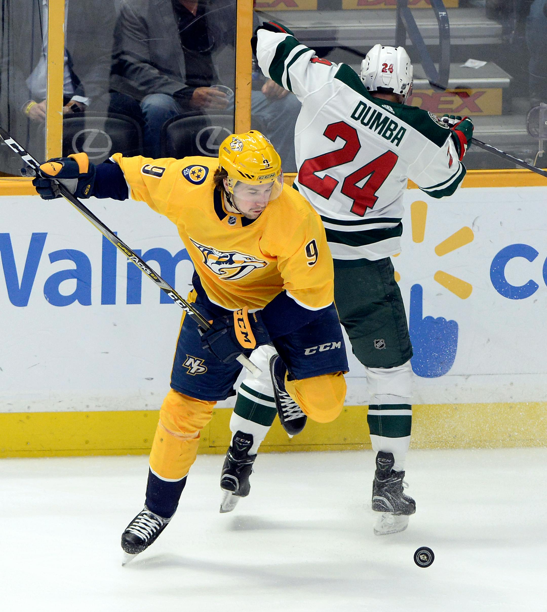 Nashville Predators left wing Filip Forsberg (9), of Sweden, tries to get control of the puck as he is defended by Minnesota Wild defenseman Matt Dumba (24) during the first period of an NHL hockey game Tuesday, March 27, 2018, in Nashville, Tenn. (AP Photo/Mark Zaleski)