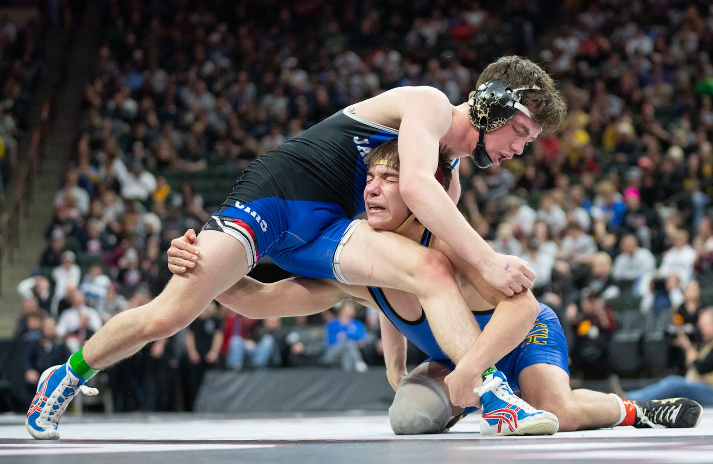 Hastings wrestler Blake Beissel goes low on Cambridge-Isanti wrestler Leo Edblad during the MSHSL wrestling state tournament championships Saturday, March 4, 2023 at Xcel Energy Arena in St. Paul, Minn. ]