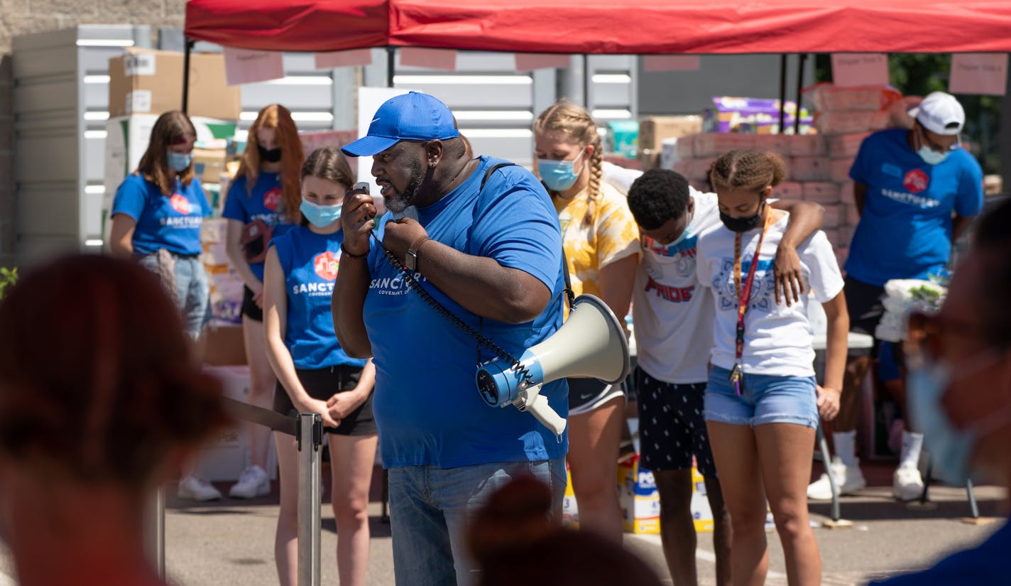 The Rev. Edrin Williams of Sanctuary Covenant Church in north Minneapolis led volunteers in prayer before opening the church's food distribution center.