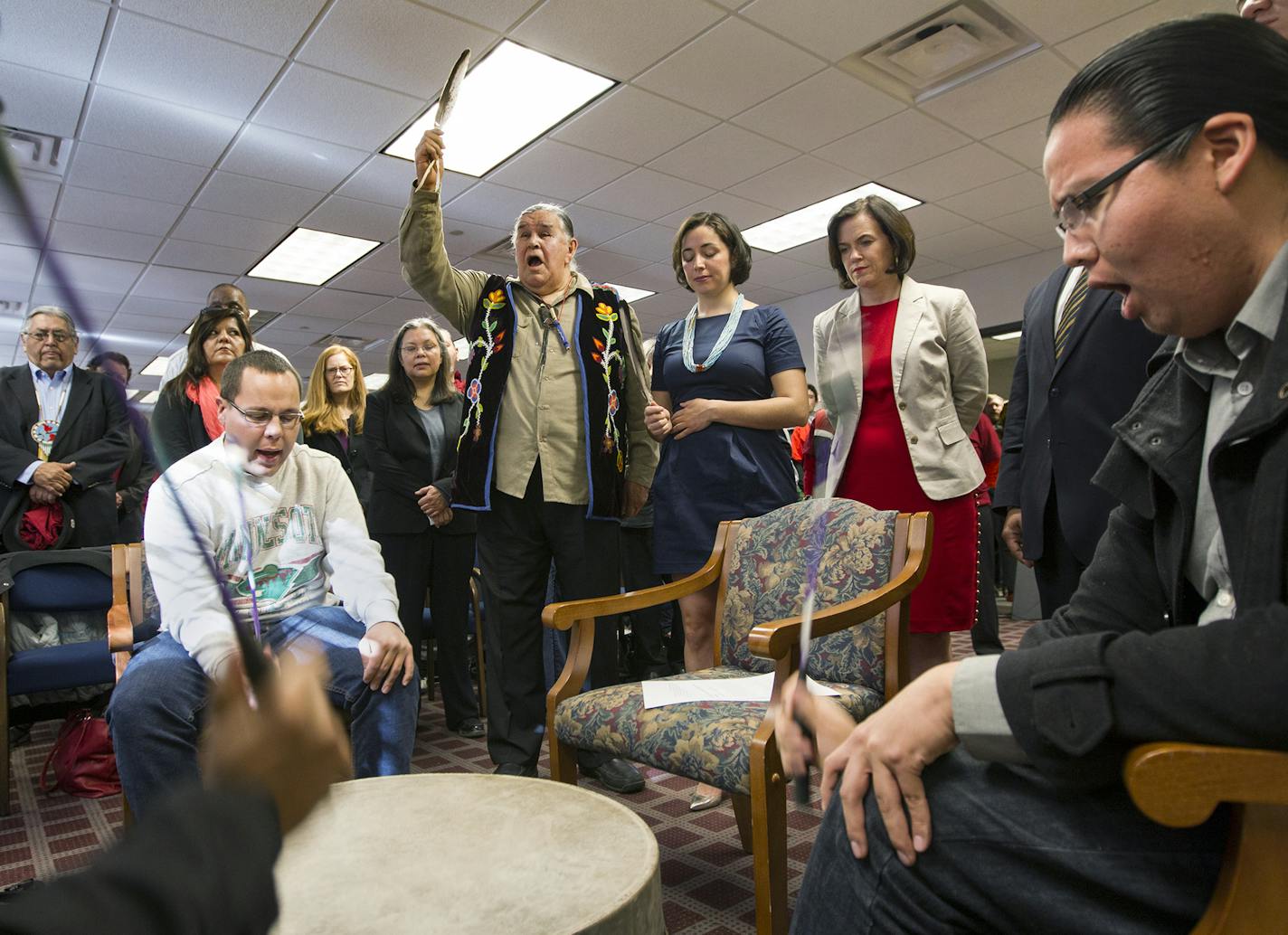 Thunder Before the Storm (Clyde Bellecourt) holds up a condor feather after leading a prayer as the Ringing Shield Drum circle sings before the Minneapolis City Council unanimously voted to call what has been known as Columbus Day "Indigenous People's Day" April 25, 2014. (Courtney Perry/Special to the Tribune)