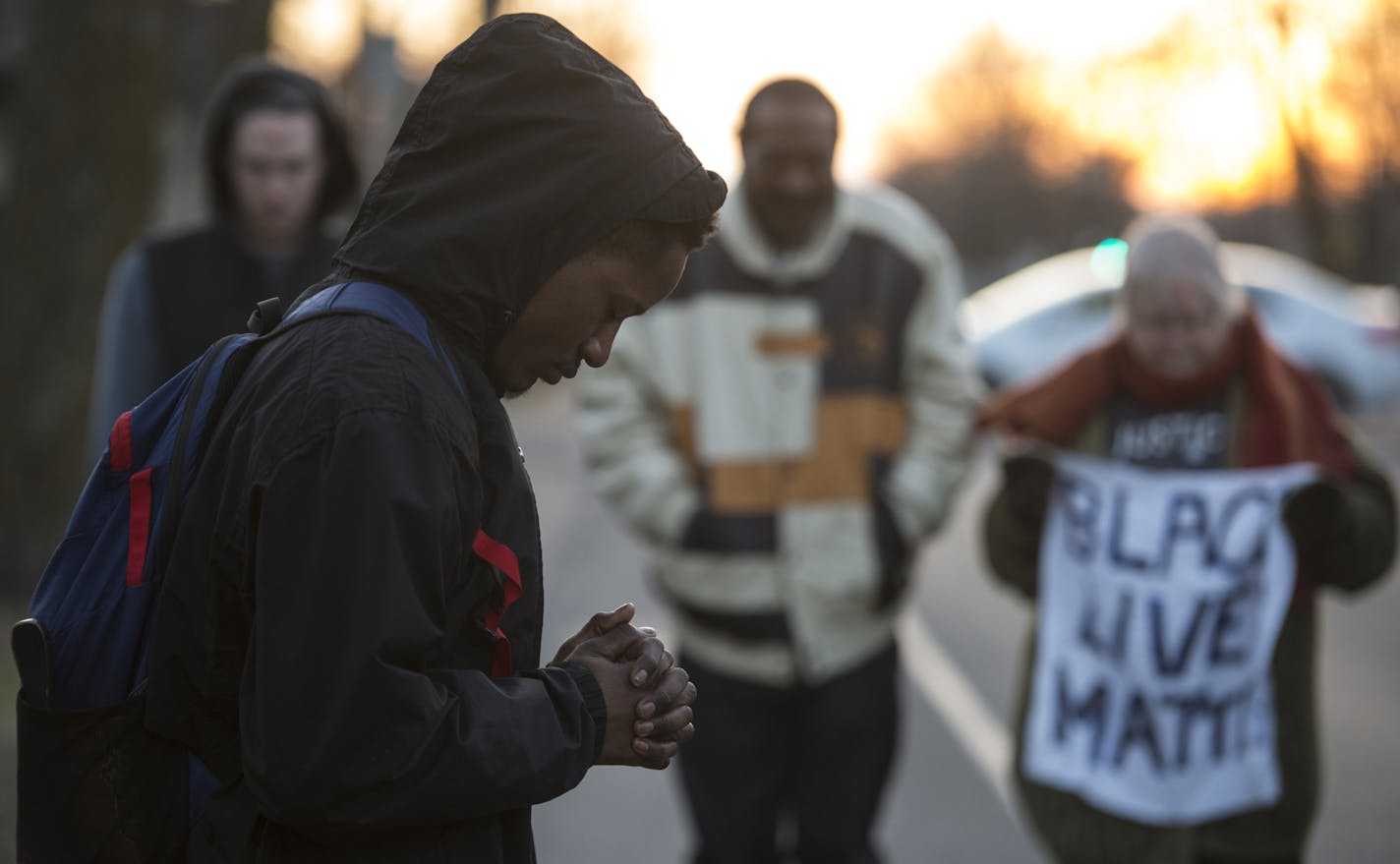 Kendrick Hall, from North Minneapolis, bowed his head in prayer during Friday afternoon's vigil in north Minneapolis. Hall is friends with Jamar Clark's cousin, Alexander.