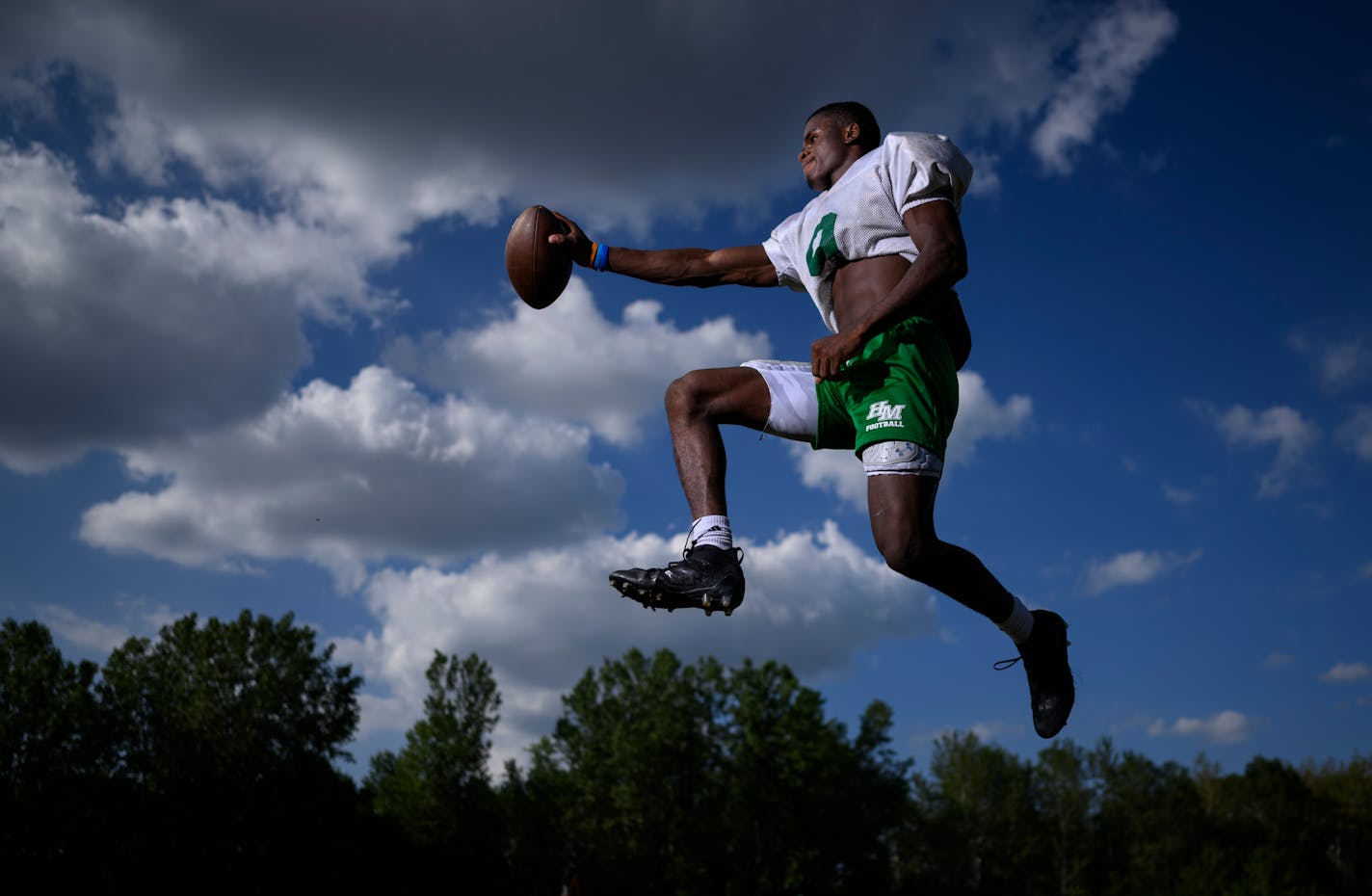 Running back Sawyer Seidl leaps for a portrait Tuesday, Aug. 23, 2022 at Hill-Murray High School in Maplewood, Minn.. Seidl is emerging as one of the top players in the metro, despite playing at a school not known for football success. He and younger brother Simon were adopted from an orphanage in Congo. ] aaron.lavinsky@startribune.com