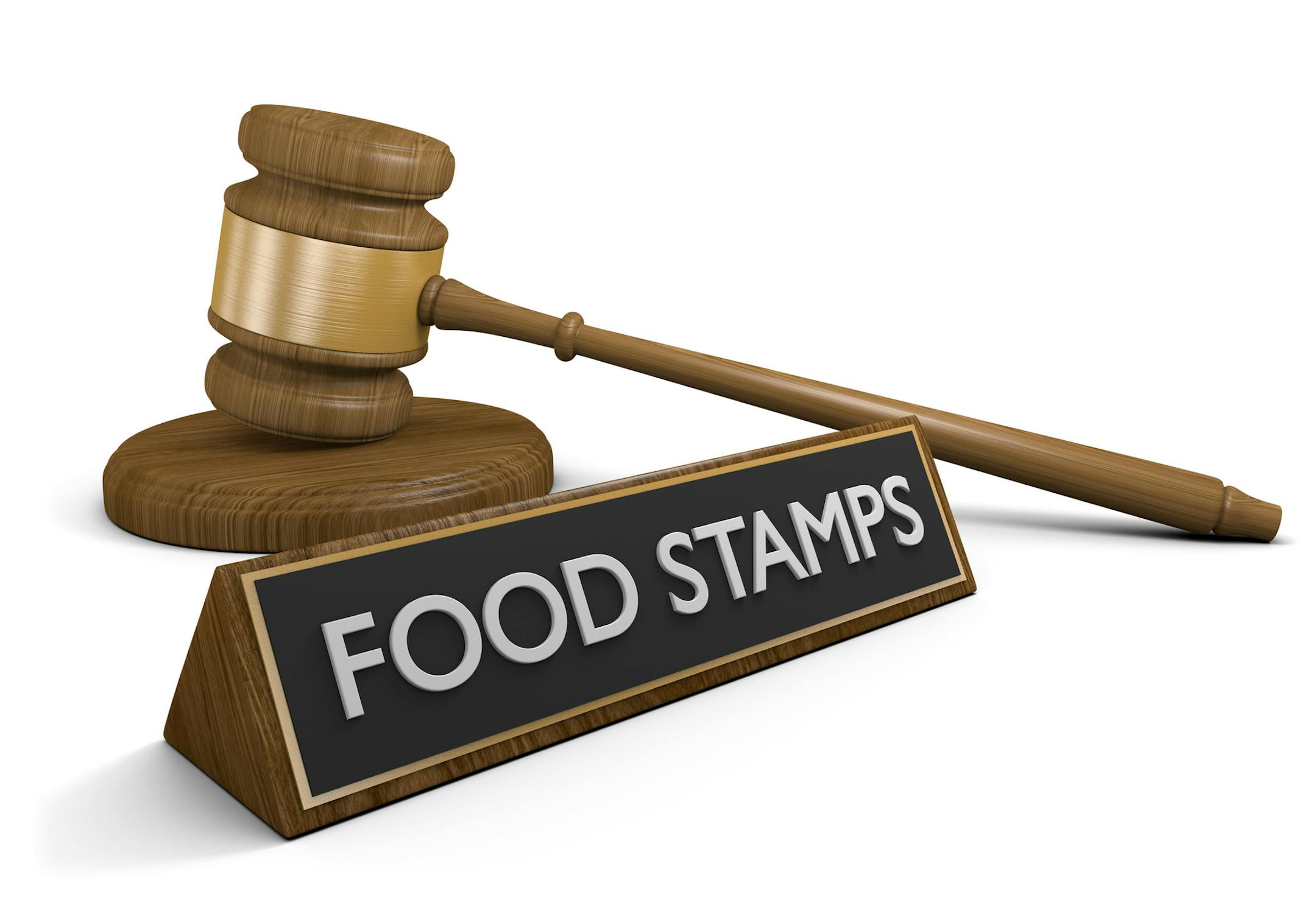 Government assistance concept of a wooden court gavel lying next to a sign that reads food stamps, rendered in 3D over a white background.