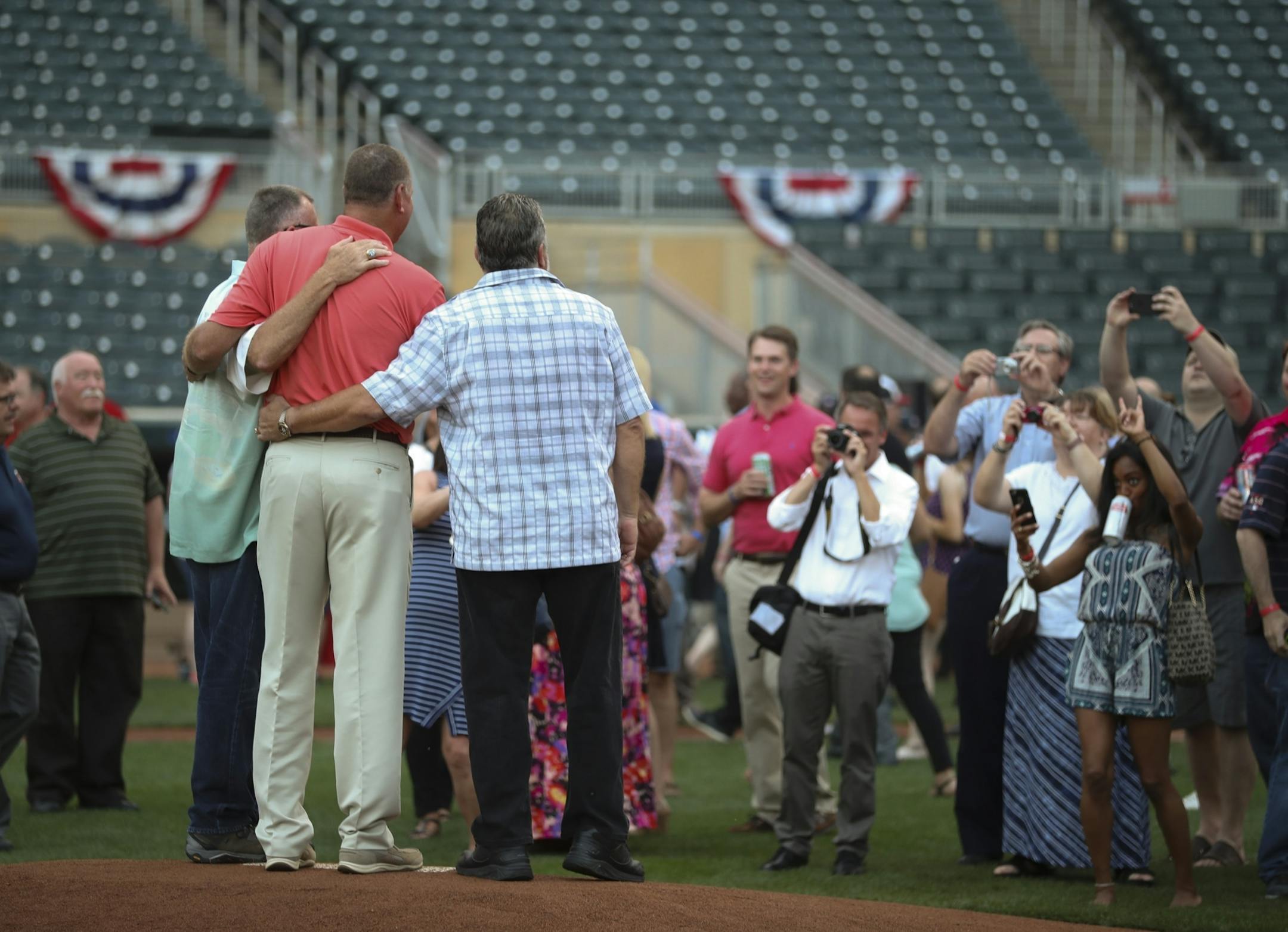 Bert Blyleven, Mike Smithson, and Jeff Reardon, from left, posed for photos on the pitcher's mound.