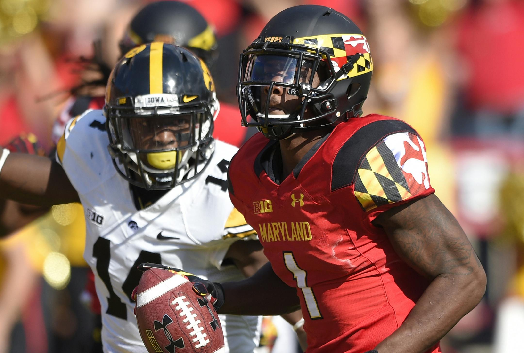 Maryland wide receiver Stefon Diggs (1) scores a touchdown against Iowa defensive back Desmond King (14) on a 53-yard run during the second half of an NCAA college football game, Saturday, Oct. 18, 2014, in College Park, Md. Maryland won 38-31. (AP Photo/Nick Wass)