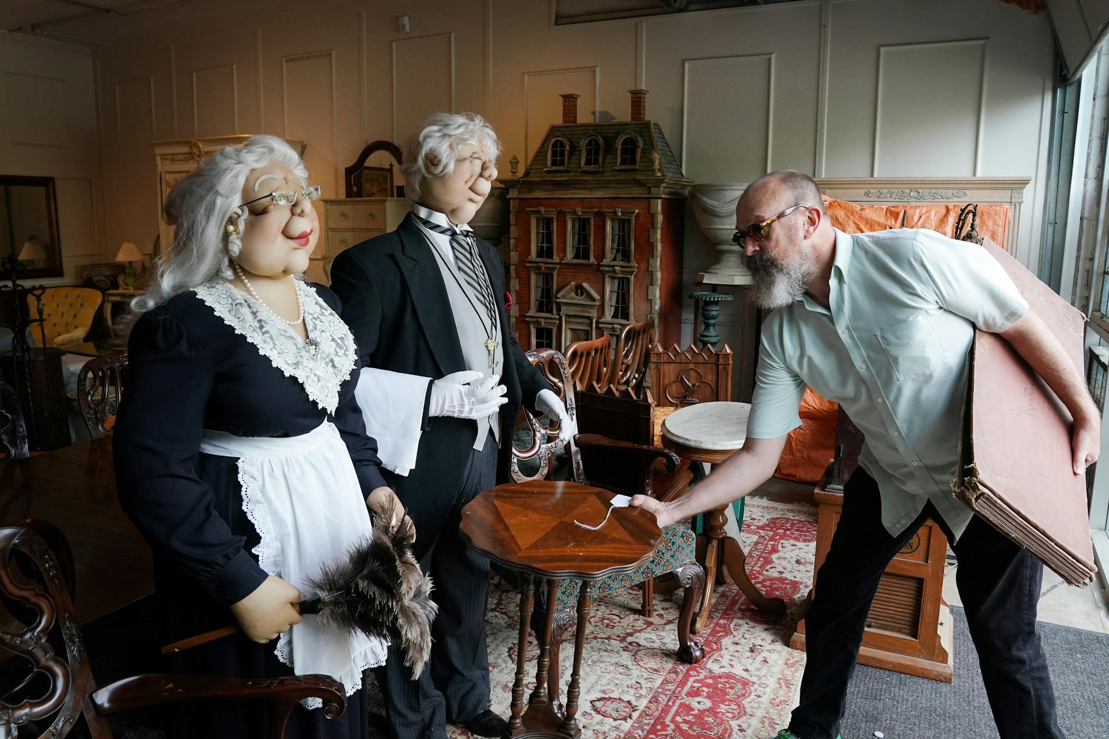 Jonathan Campbell placed an unrelated table near a pair of dummies from the Pillsbury mansion, recently demolished on Lake Minnetonka, as they sat with the home's other furnishings that will go up for sale this weekend at H & B Gallery.