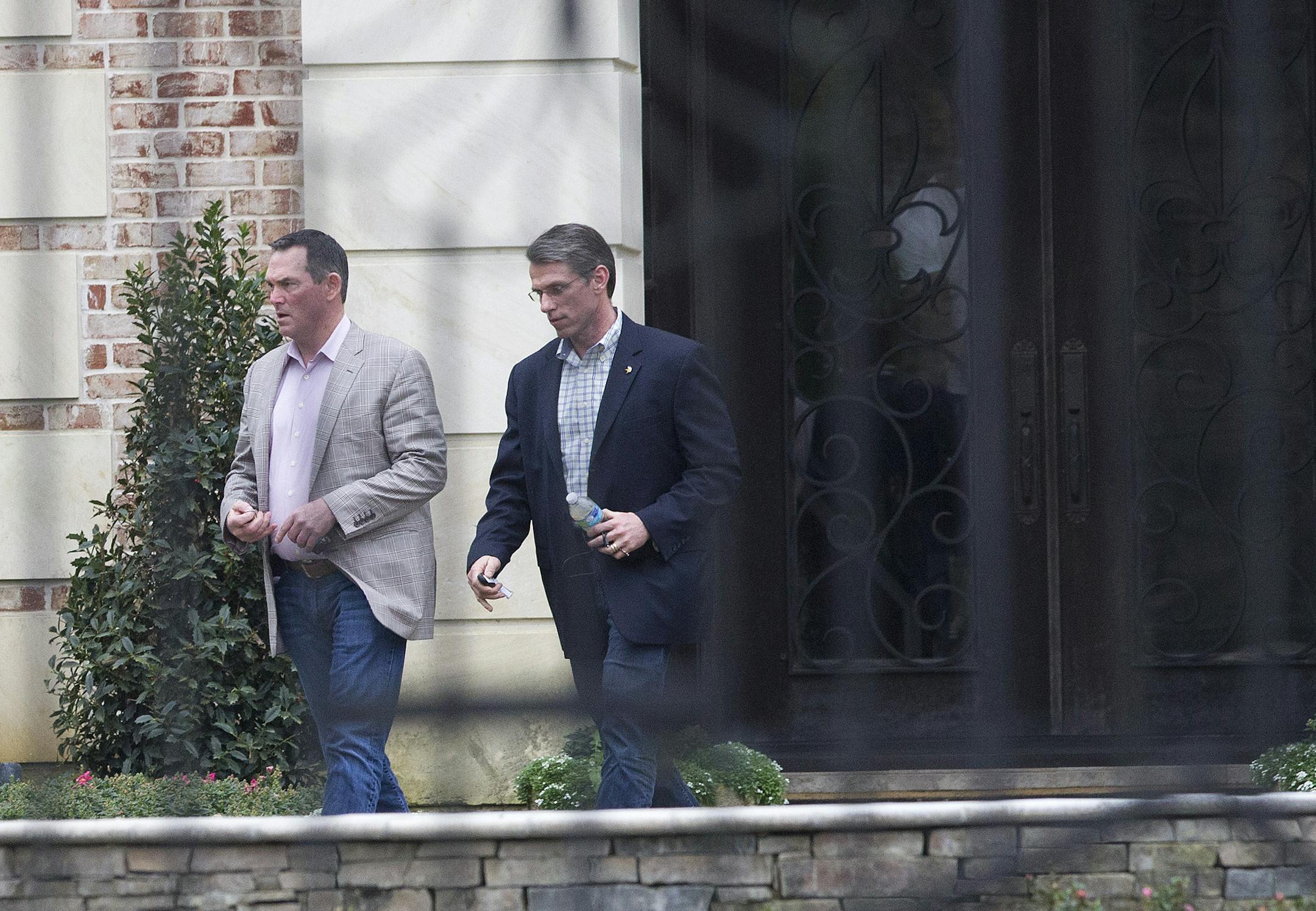 Minnesota Vikings head coach Mike Zimmer, left, and general manager Rick Spielman leave the home of NFL running back Adrian Peterson, Wednesday, March 4, 2015. in The Woodlands, Texas. Zimmer and Spielman met with Peterson to discuss his future with the NFL football team. (AP Photo/Conroe Courier, Jason Fochtman)