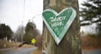 A green, chalkboard-like heart, a small remembrance of the mass shooting at Sandy Hook Elementary, is nailed to a utility pole in Newtown, Conn., Dec.