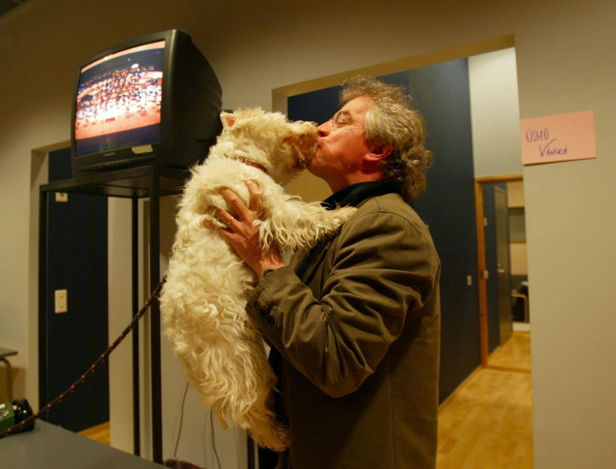 LAHTI - 2/26/04 - The Minnesota Orchestra arrived in their music director Osmo Vanska's homeland on a snowy Thursday evening for a concert at Sibelius Hall in Lahti. IN THIS PHOTO: Osmo Vanska was greeted with a big wet kiss by...his dog, Lilja, who was brought backstage at Sibelius Hall by Vanska's daughter, Tytti Vanska before Thursday evening's touch-up rehearsal. Vanska and the orchestra arrived from Scotland just in time for a rehearsal for Thursday night's concert. "He always arrives just